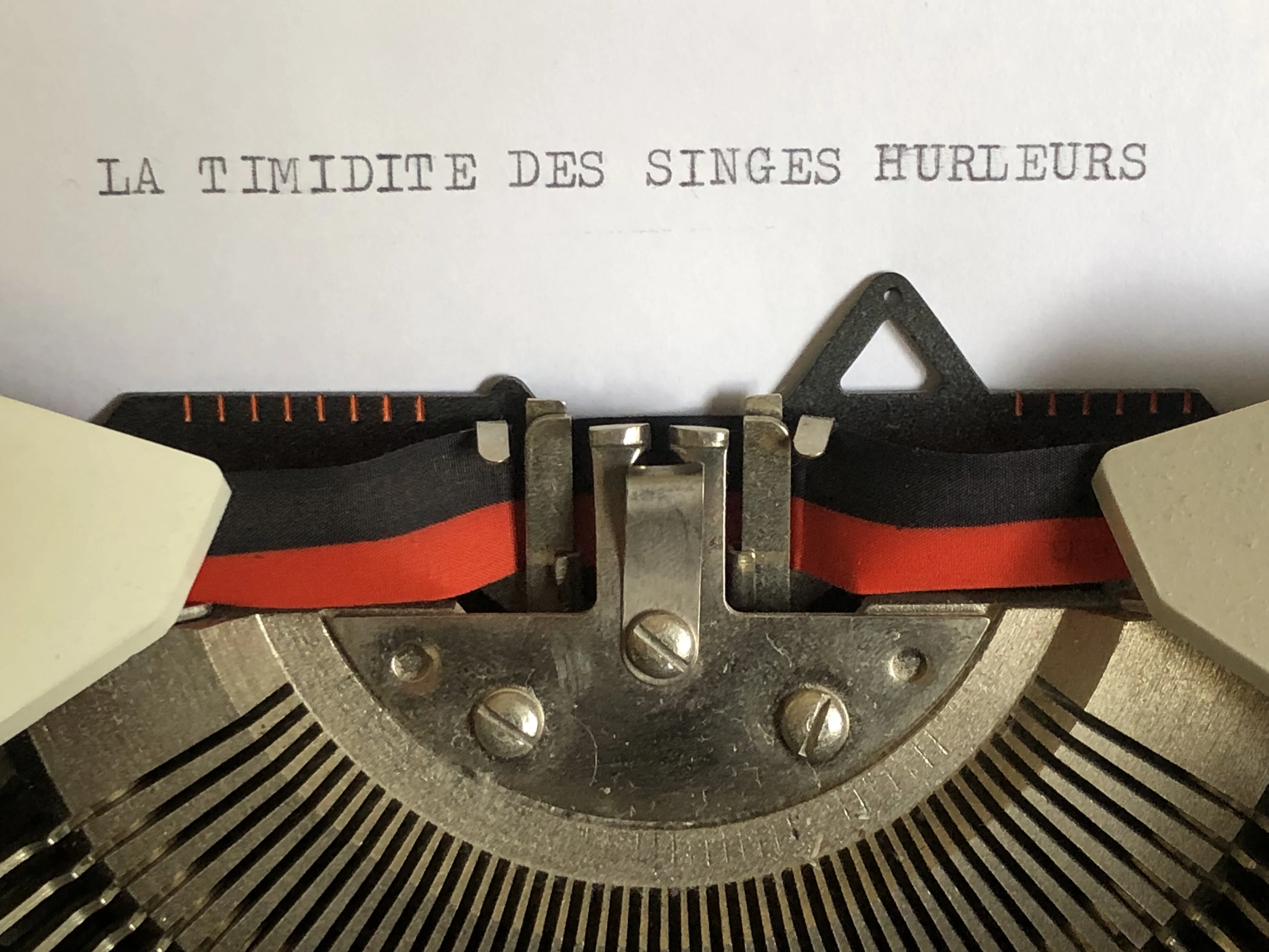 Machine à écrire avec un papier titré La timidité des singes hurleurs
