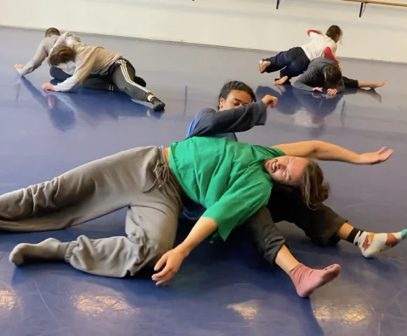 Atelier de danse contact, plusieurs personnes au sol explorant le toucher